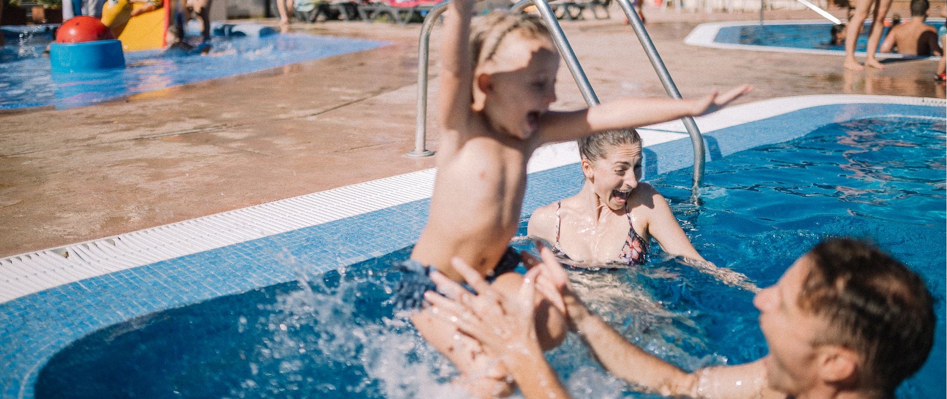 Happy children with their father in the pool