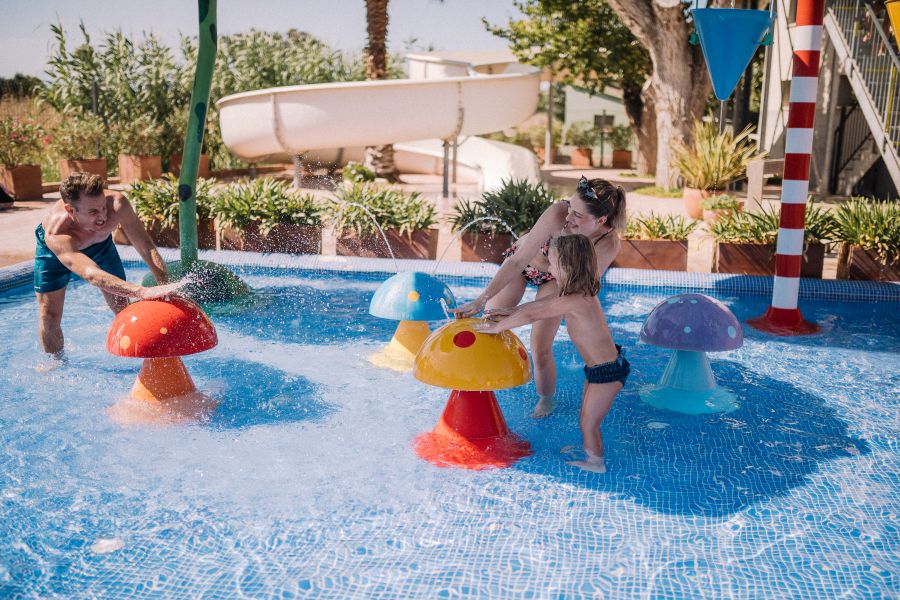Family with young children playing in swimming pool
