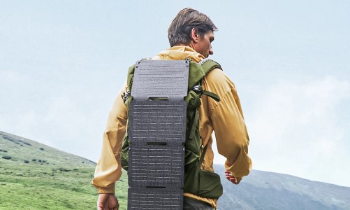 Panel solar portátil Anker Solix PS30 desplegado sobre una mochila durante una ruta de senderismo