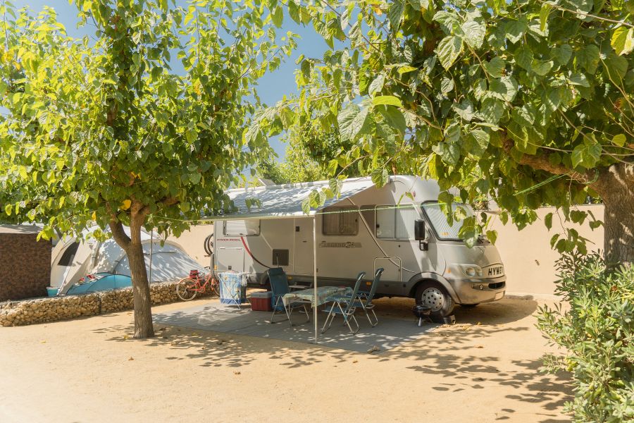 autocaravana instalada con avance en una parcela amplia de un camping Sènia
